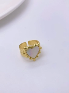 Detail shot of a vintage gold heart ring with shell inlay and textured hammered finish