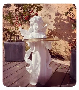 Close-up of white angel sculpture holding a golden tray for entryway decor