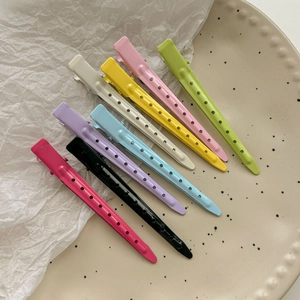 Set of 8 colorful matte alloy seamless hair clips for styling arranged on a decorative plate