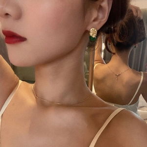 Vintage gold petal earrings and necklace set with green jade beads on a model