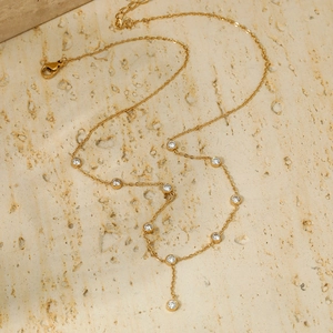 Minimalist gold stainless steel chain necklace with sparkling zircon stones on stone surface