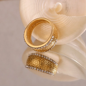 Detailed macro view of 18K gold plated hammered texture ring with white zircon borders