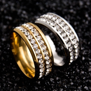 Close-up of gold and silver titanium steel rings with double-row pavé crystals
