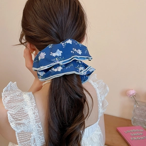 Detail of blue floral scrunchie with rabbit patterns on a high ponytail hairstyle