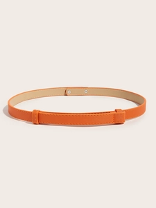 Detailed macro view of orange Saffiano leather belt with adjustable slide buckle