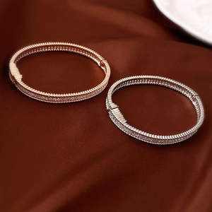 Detailed view of rose gold and silver snap bracelets with micro-paved zircons and textured edges