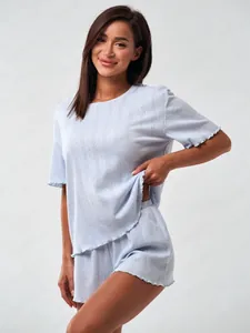 Close-up of light blue ribbed cotton pajama set featuring delicate ruffled edges and texture
