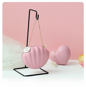 Detail of pink shell-shaped candy box with golden chain, pearls and Forever Love tag