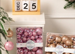 Detail view of pink and champagne gold Christmas ornaments in a window gift box packaging