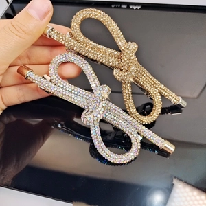 Primo piano di fermagli per capelli a fiocco con strass brillanti e base in metallo elegante