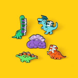 Five-piece cartoon dinosaur enamel pin set featuring cute colorful reading motifs