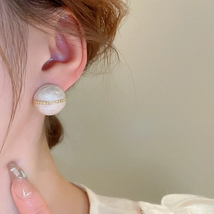 Detail of vintage semi-circle stud earrings with gold plating and marble texture