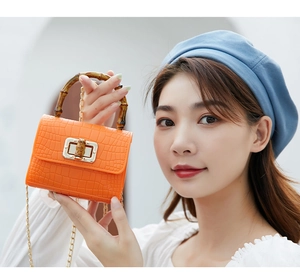 Orange crocodile texture mini bag with bamboo handle and gold chain strap