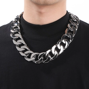 Close-up of polished 30mm wide silver Cuban chain necklace on male model neck