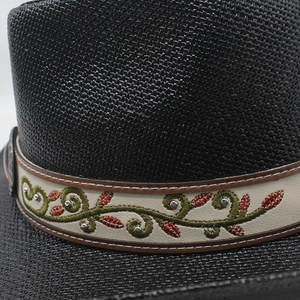 Vue détaillée d'un chapeau de cowboy noir tressé avec broderie florale et clous argentés