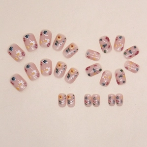 Short square press-on nails with colorful floral patterns and a translucent pink base