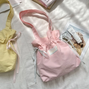 Detail of drawstring canvas tote bag with satin ribbon and high-density nylon texture