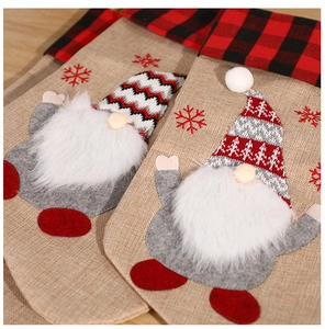 Détail d'une chaussette de Noël avec gnome, bordure à carreaux rouges et barbe en fourrure