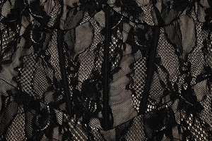 Detail of black lace dress showing intricate floral texture and corset-style boning structure