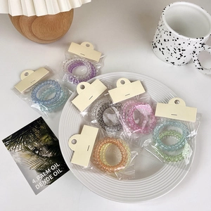 Gradient candy-colored spiral hair ties in various shades displayed on a ceramic plate