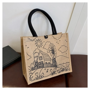 Detailed close-up of a linen tote bag with windmill print and black rope handles
