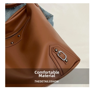 Macro view of brown leather bag with metallic rivets and strap detail