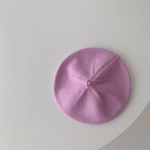 Detailed close-up showing soft lavender purple knitted texture of baby's beret hat