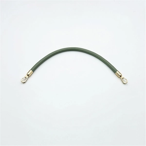 Detailed view of flexible green PU leather bag strap with gold metal lobster clasps