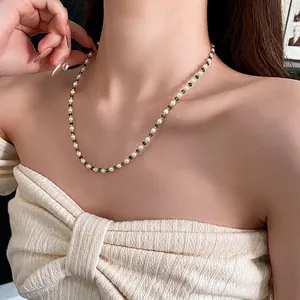 Elegant gold plated pearl necklace with green faceted beads shown on a female model