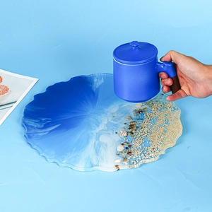 Detail of round ocean theme resin tray with real sand, shells and waves texture