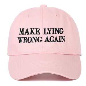 Dettaglio del ricamo nero Make Lying Wrong Again su un berretto di cotone rosa