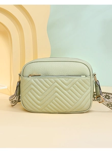 Dettaglio borsa in pelle litchi verde chiaro con trapuntatura e tracolla in tessuto