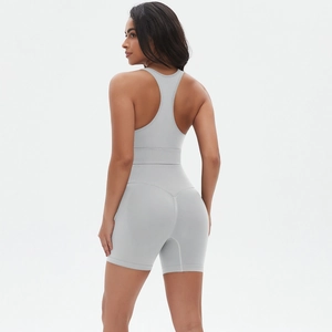Dettaglio del reggiseno sportivo incrociato grigio chiaro e pantaloncini a vita alta senza cuciture
