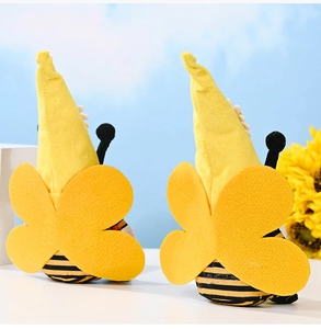 Close-up of plush bee gnomes with yellow wings and striped bodies on a bright background