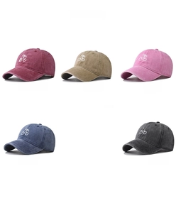 Close-up of five washed cotton baseball caps with cherry embroidery in various colors