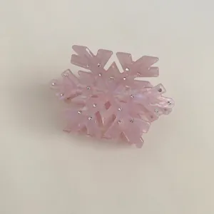 Detailed shot of pink acetate snowflake hair claw with sparkling crystals and pearl luster