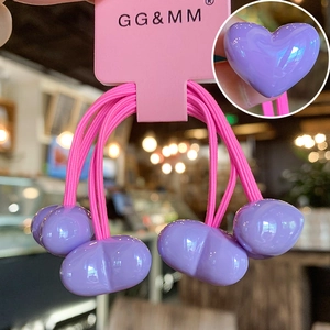 Detail of purple elastic hair ties with heart pendants and brand display card