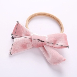 Detail showing 10cm velvet bow on a nylon baby headband with size annotations