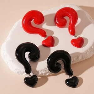 Exaggerated resin earrings featuring large question mark and heart pendants in red and black