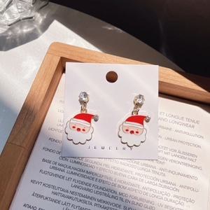 Detail of Christmas Santa Claus earrings with red enamel and sparkling crystal accents