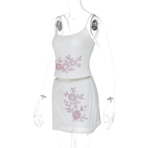 Detail of white two-piece skirt set with pink rhinestones on a ghost mannequin
