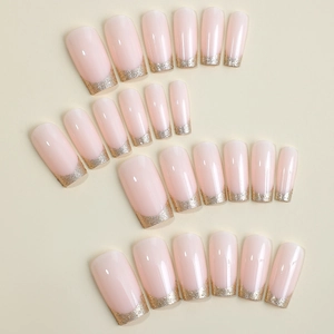 Elegant French press-on nails in nude pink with golden glitter tips and various sizes