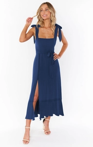 Close-up of navy blue midi dress featuring adjustable bow straps and square neckline