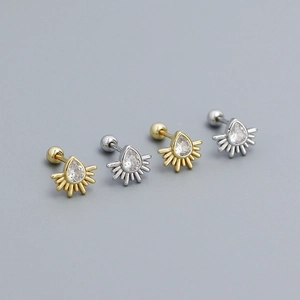 Macro detail of gold and silver teardrop zircon stud earrings with sunburst fan design