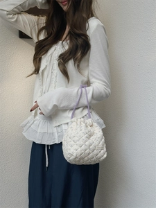 Detailed view of the quilted floral drawstring travel storage bag held by a model