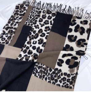 Detailed view of leopard print scarf with patchwork blocks and soft tassel edges