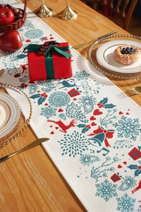 Modern Christmas table runner with reindeer and snowflake print on a wooden dining table