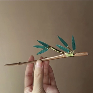 Détail de l'épingle à cheveux chinoise en bambou avec feuilles vertes et fil doré fin