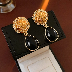 Detail of vintage flower earrings with black water drop pendant on a jewelry box