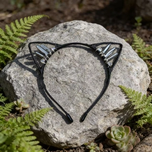 Detailed shot of black cat ear headband with silver crystals on natural rock and ferns